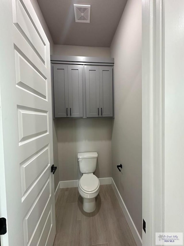 bathroom with hardwood / wood-style flooring and toilet