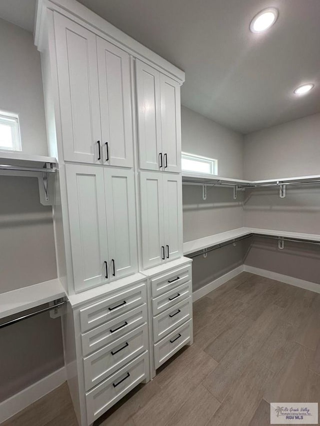 spacious closet with light hardwood / wood-style flooring