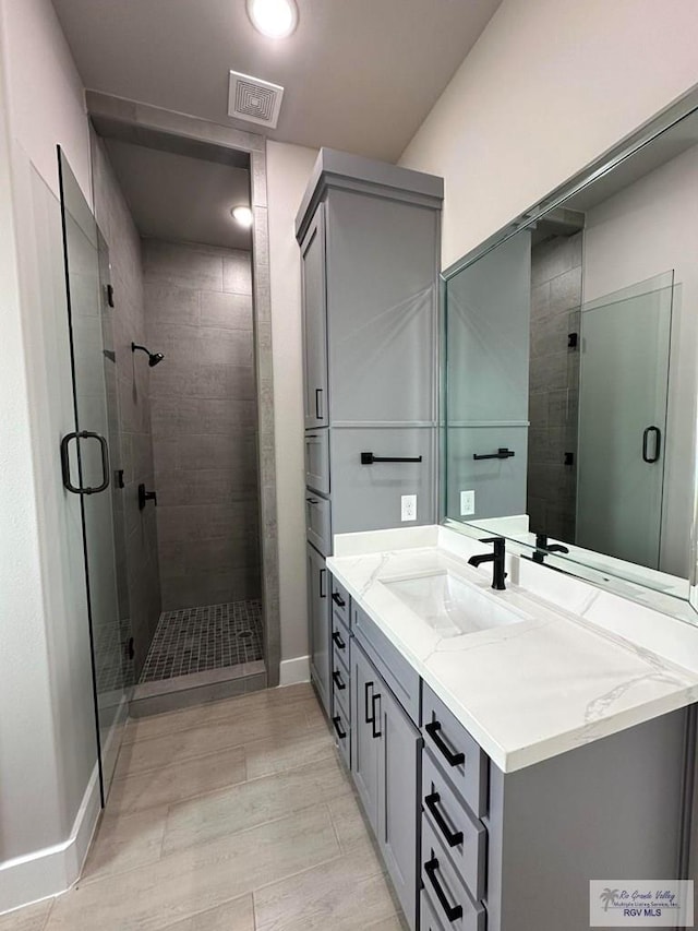 bathroom with vanity and a shower with shower door