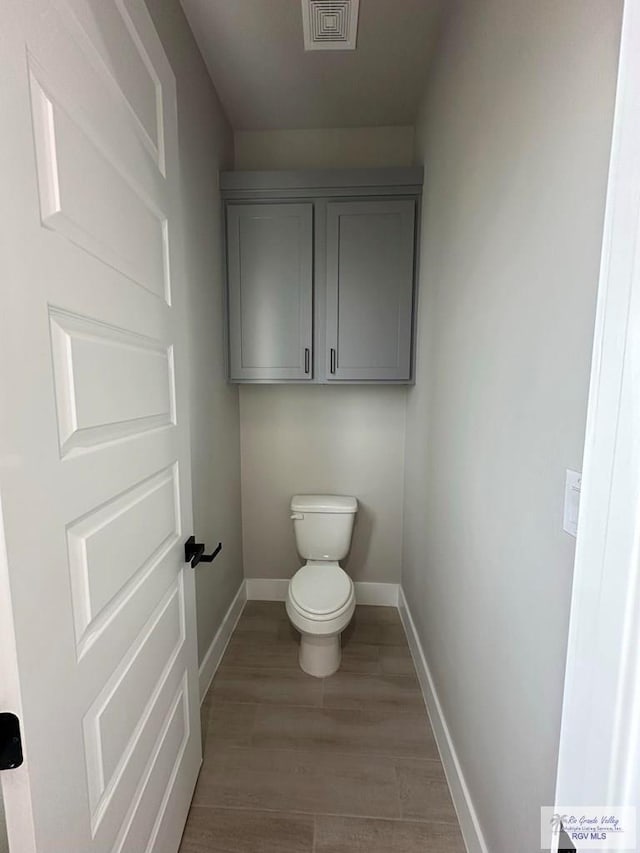 bathroom featuring toilet and wood-type flooring