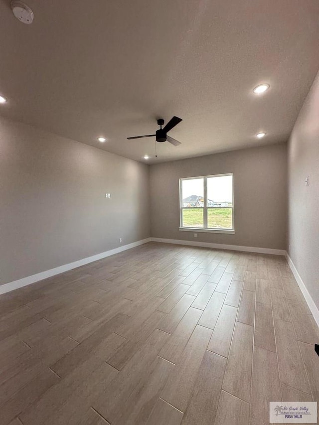 empty room featuring a textured ceiling, hardwood / wood-style floors, and ceiling fan