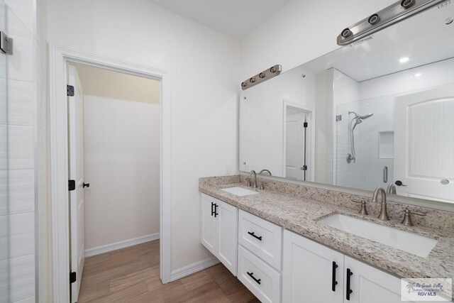 bathroom with hardwood / wood-style floors, vanity, and an enclosed shower