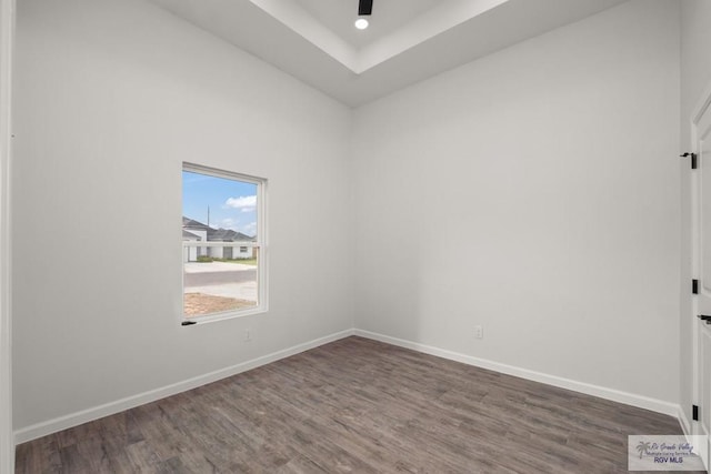 empty room featuring a ceiling fan, wood finished floors, and baseboards