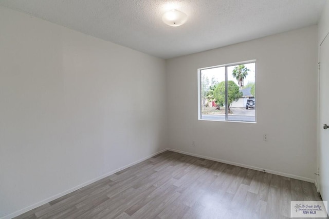 225 Chelo Dr, La Feria, TX 78559 - unfurnished room featuring baseboards, a textured ceiling, and light wood-style flooring