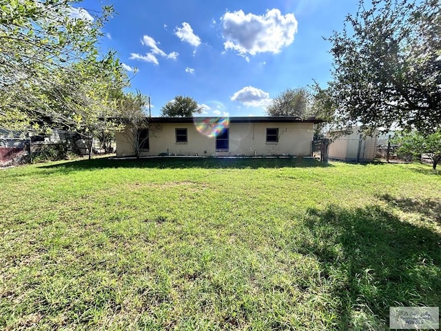 rear view of house featuring a yard