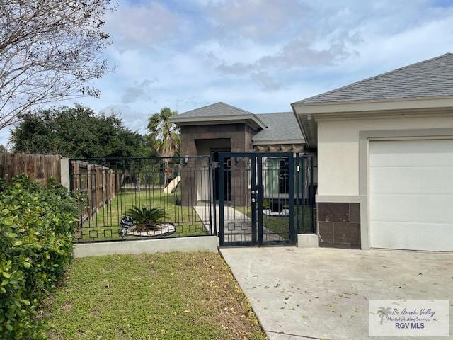 view of gate featuring a lawn and a garage