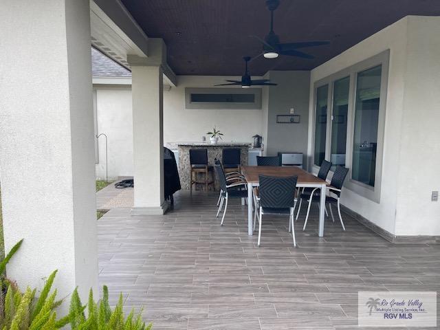 view of patio featuring ceiling fan and an outdoor bar