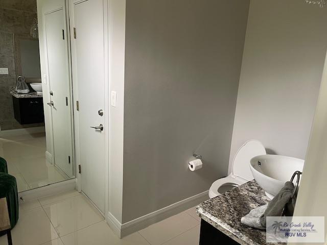 bathroom featuring tile patterned flooring, a shower with door, and vanity