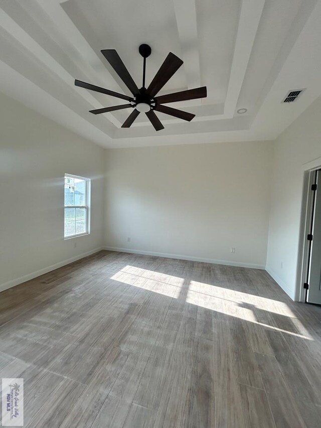 spare room featuring coffered ceiling, wood finished floors, and beam ceiling