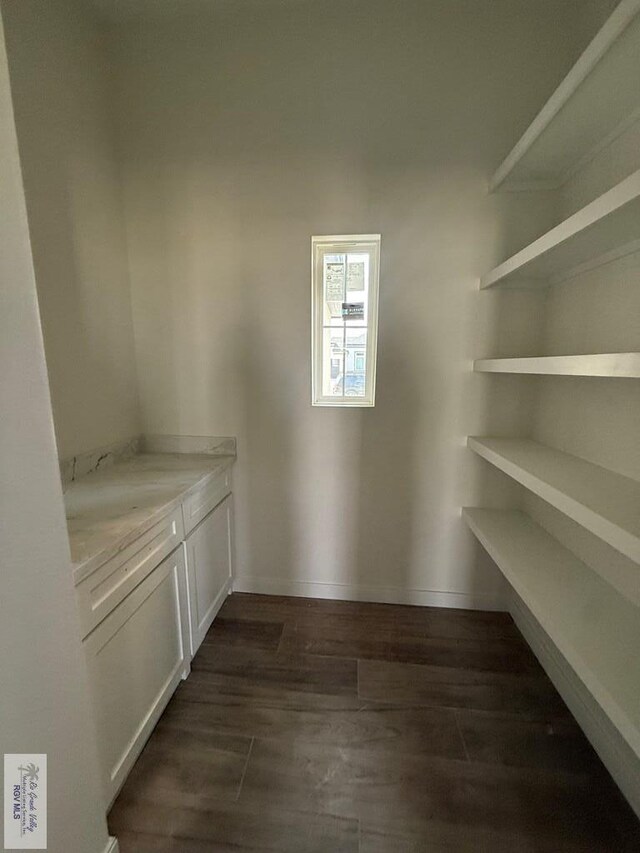 unfurnished living room with high vaulted ceiling, beamed ceiling, and wood-type flooring