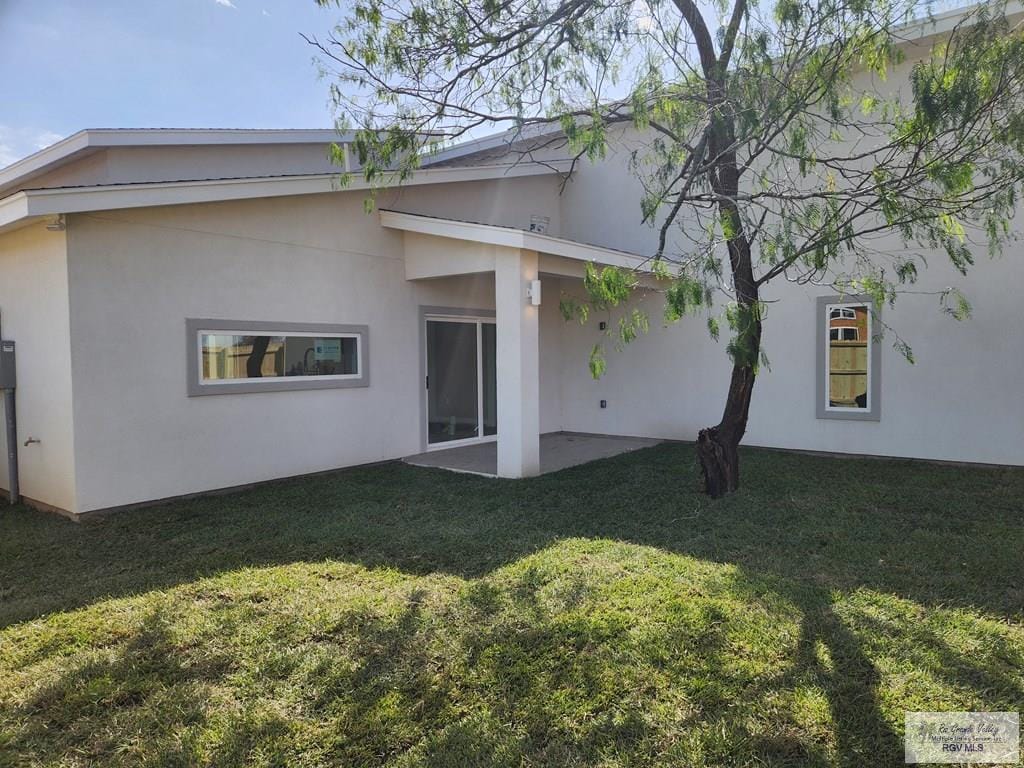 back of house featuring a patio area and a yard