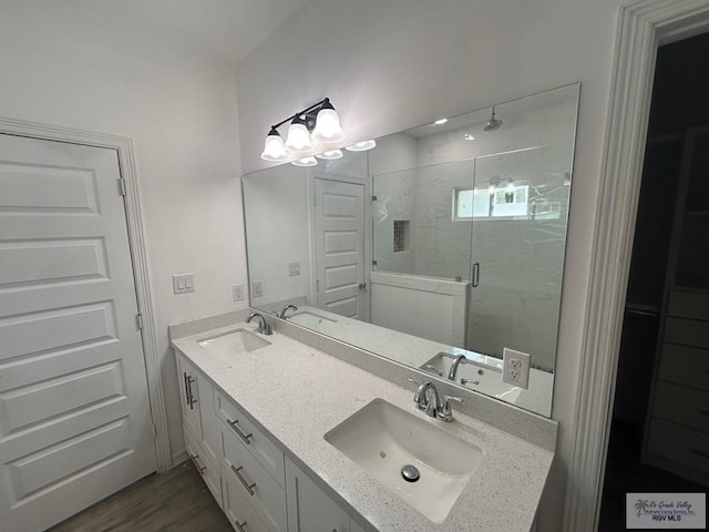 6214 Bentwood Dr, Harlingen, TX 78552 - bathroom with a marble finish shower, double vanity, and wood finished floors