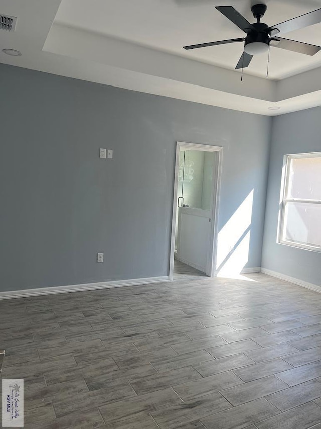 6214 Bentwood Dr, Harlingen, TX 78552 - empty room featuring a raised ceiling, ceiling fan, and wood tiled floors