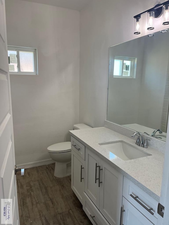 bathroom featuring vanity, hardwood / wood-style flooring, and toilet