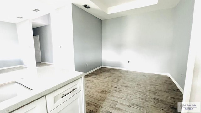 interior space featuring light hardwood / wood-style floors, white cabinetry, and sink