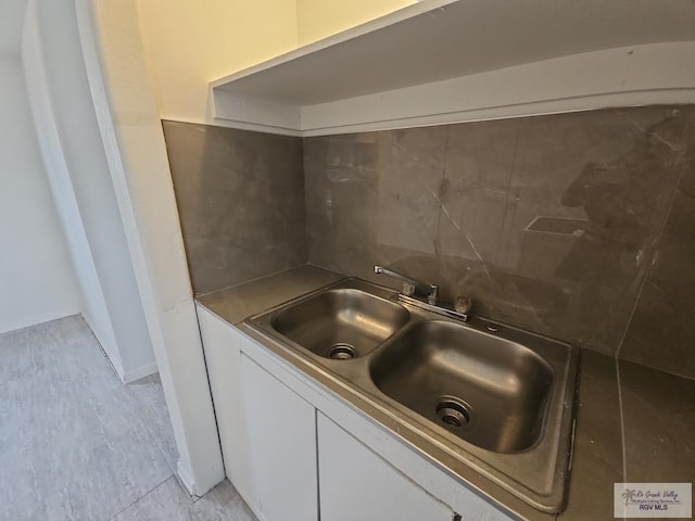 kitchen featuring white cabinetry and sink