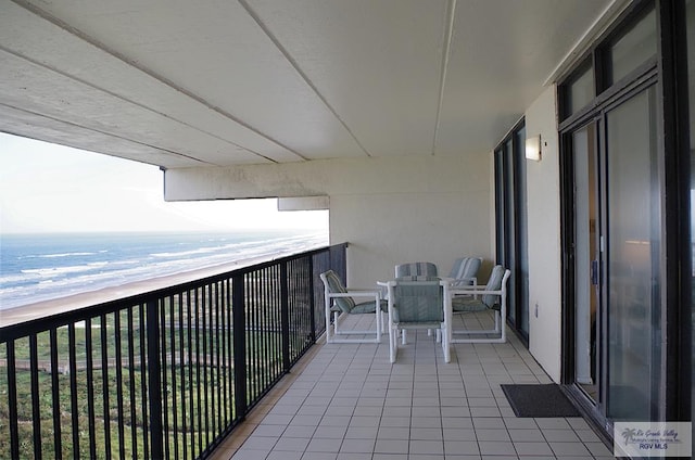 balcony featuring a water view and a view of the beach