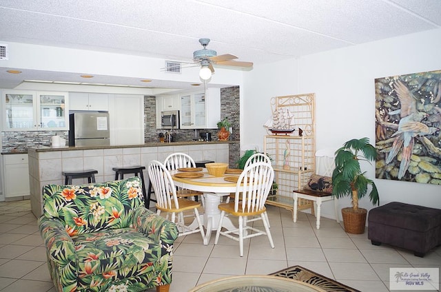 tiled dining room featuring ceiling fan and a textured ceiling