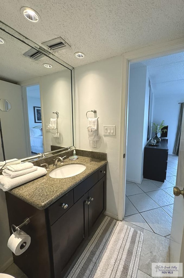 bathroom with tile patterned floors, vanity, and a textured ceiling