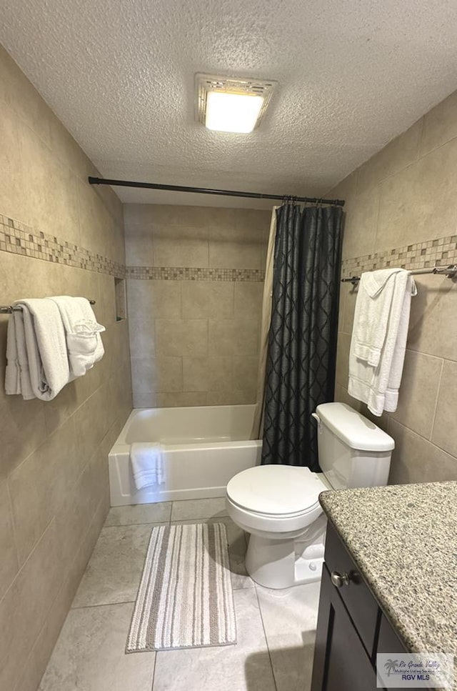 full bathroom featuring a textured ceiling, vanity, tile walls, and toilet