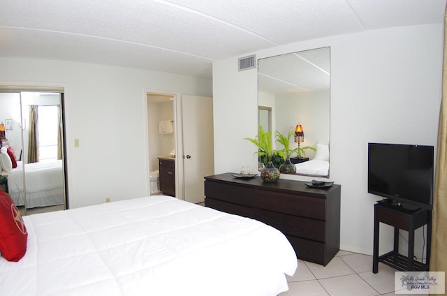 bedroom with light tile patterned floors and connected bathroom