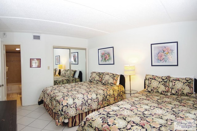 bedroom with light tile patterned floors and a closet