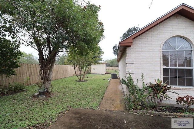 view of yard with central AC unit and a storage unit