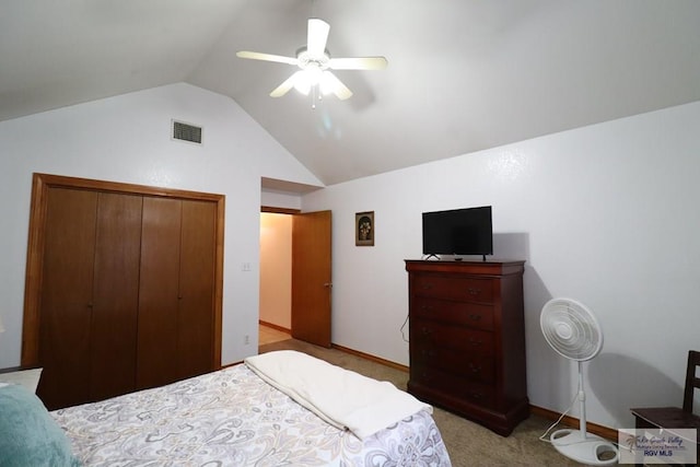 bedroom featuring ceiling fan, light colored carpet, a closet, and vaulted ceiling