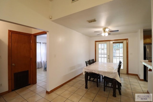 tiled dining space with ceiling fan and french doors