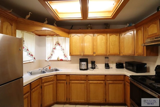 kitchen with black appliances, light tile patterned floors, and sink