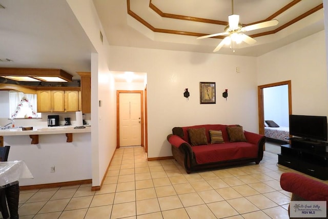 living room with ceiling fan, light tile patterned flooring, and a raised ceiling