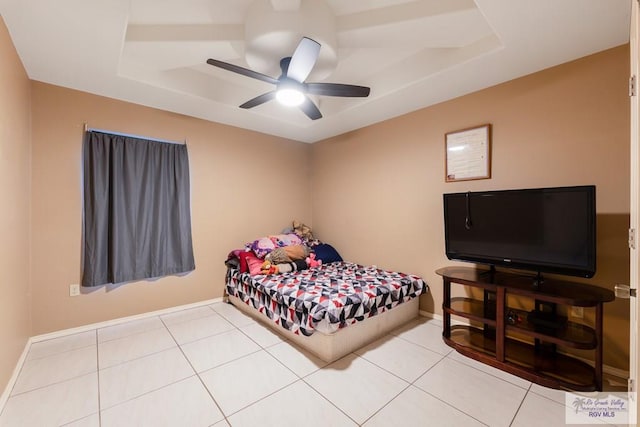 bedroom featuring a tray ceiling, ceiling fan, and tile patterned flooring