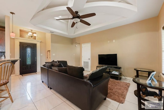 living room featuring light tile patterned floors, a tray ceiling, and ceiling fan