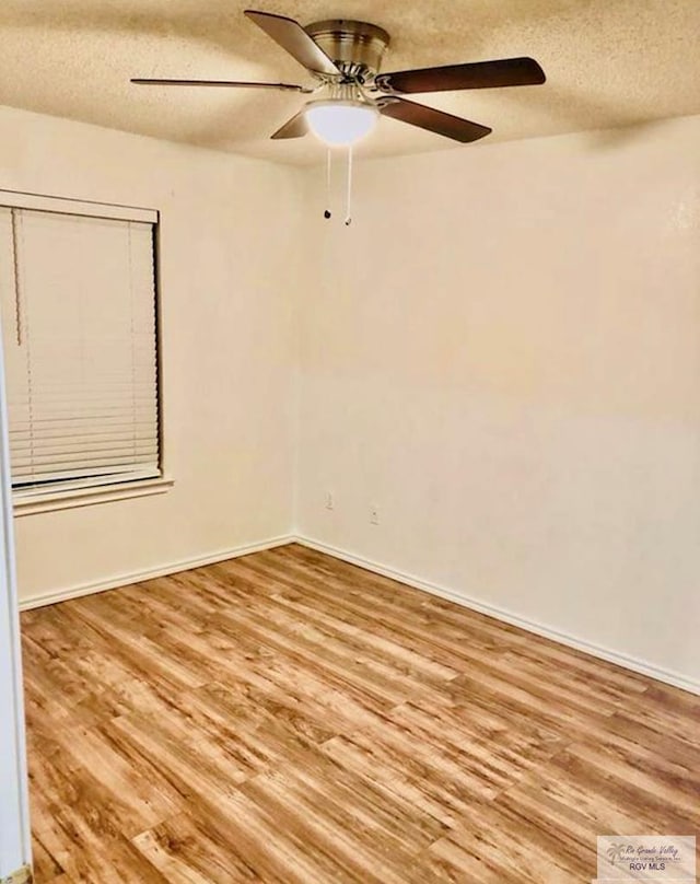 empty room with a textured ceiling and light wood-type flooring