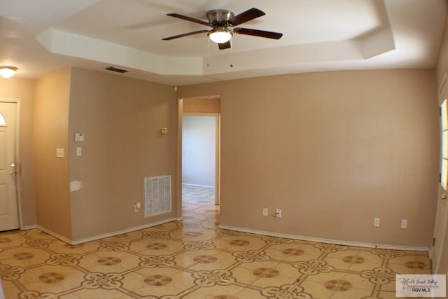 unfurnished room with a tray ceiling and ceiling fan