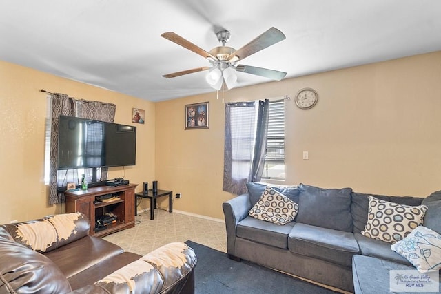 living room with baseboards and a ceiling fan