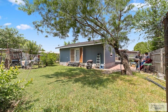 back of house with entry steps, fence private yard, and a yard