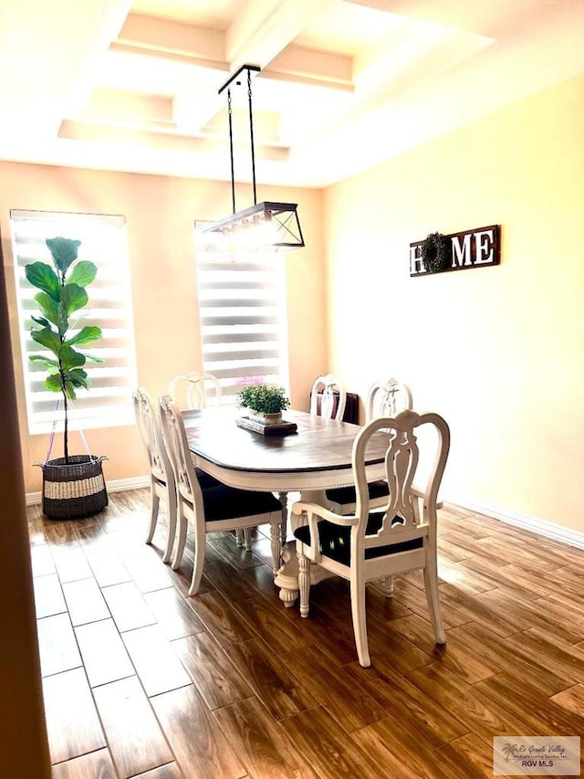 dining space with baseboards, coffered ceiling, wood finished floors, and beamed ceiling