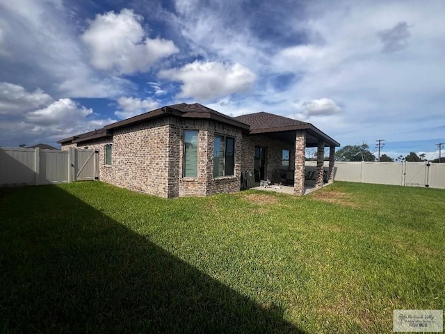 view of side of home with a gate, a fenced backyard, and a lawn