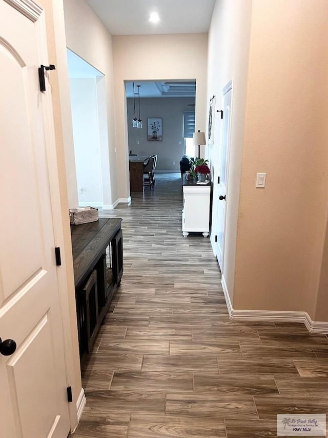 hall with baseboards and wood tiled floor