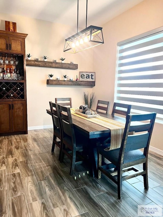 dining area with baseboards and wood tiled floor