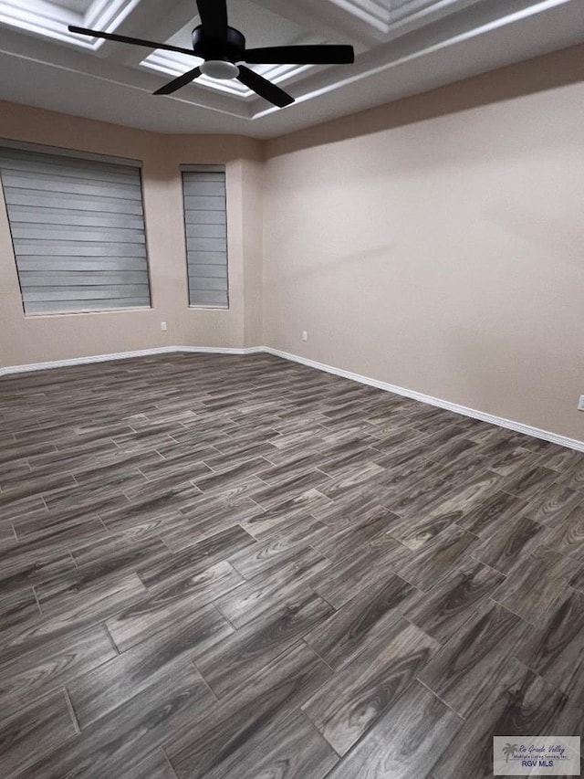 spare room with baseboards, a ceiling fan, and dark wood-style flooring