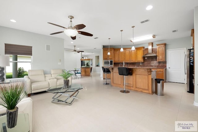 tiled living room featuring ceiling fan and sink