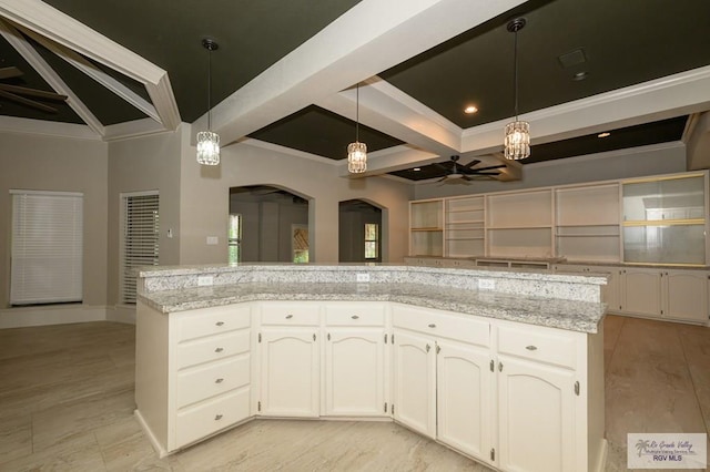 1101 Chico Cir, Harlingen, TX 78552 - kitchen featuring white cabinetry, beamed ceiling, decorative light fixtures, ceiling fan, and arched walkways