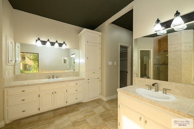 1101 Chico Cir, Harlingen, TX 78552 - bathroom featuring baseboards, a shower stall, two vanities, and a sink