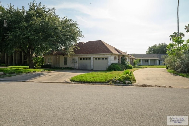 1101 Chico Cir, Harlingen, TX 78552 - ranch-style house featuring an attached garage, driveway, and a front yard