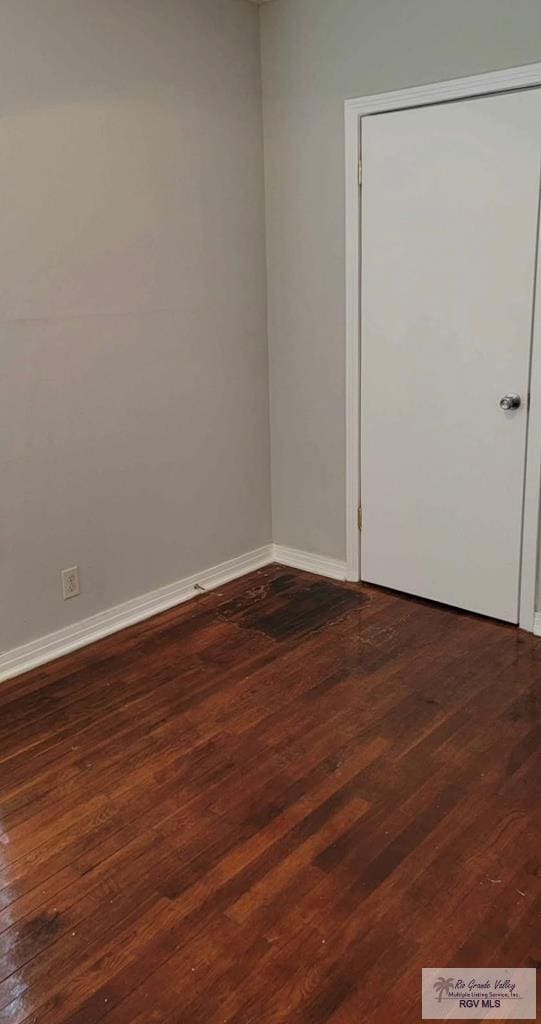 spare room featuring dark wood-type flooring