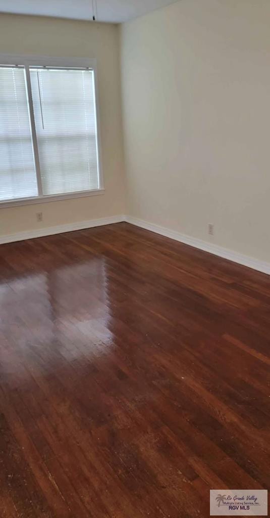 spare room with dark wood-type flooring