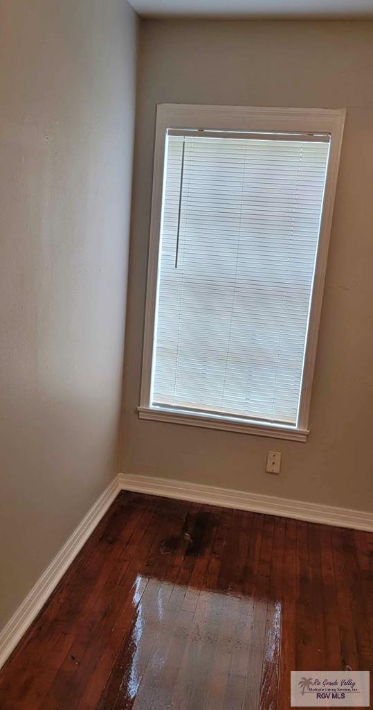 spare room featuring dark wood-type flooring