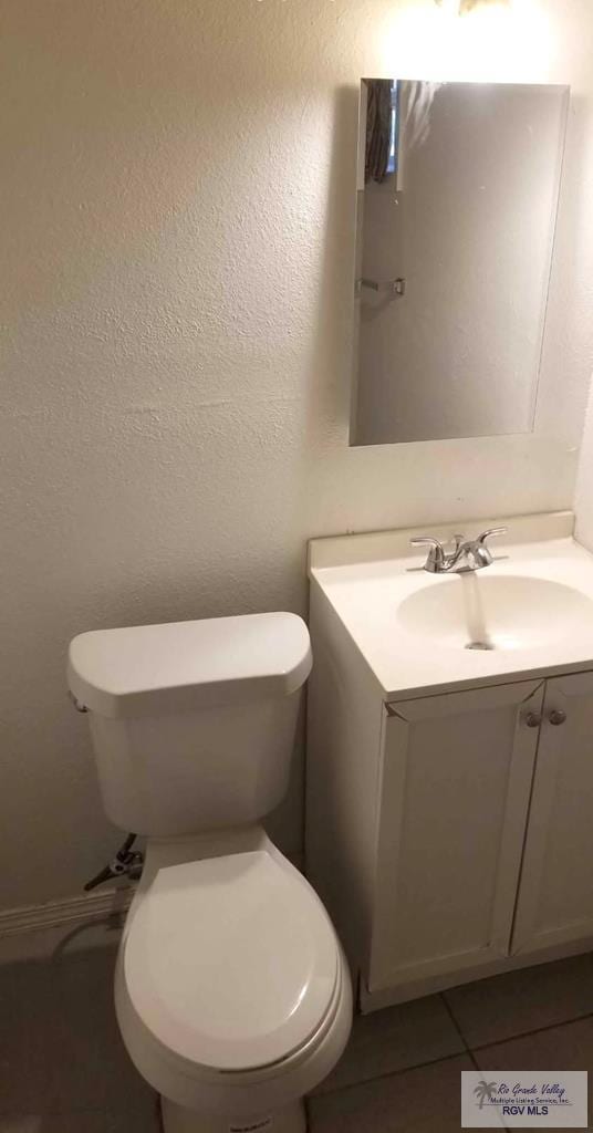 bathroom featuring vanity, tile patterned floors, and toilet